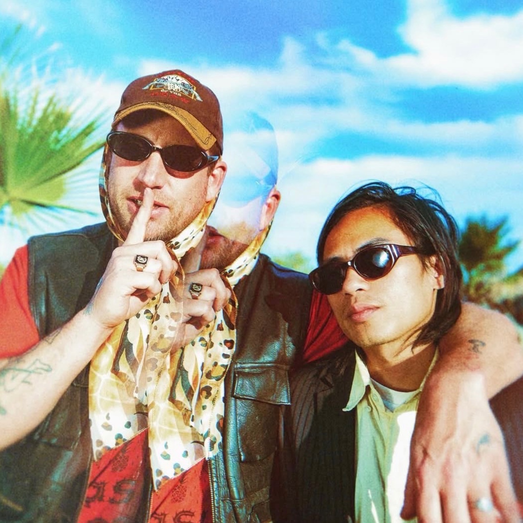 Two men posing with a blue sky in the back