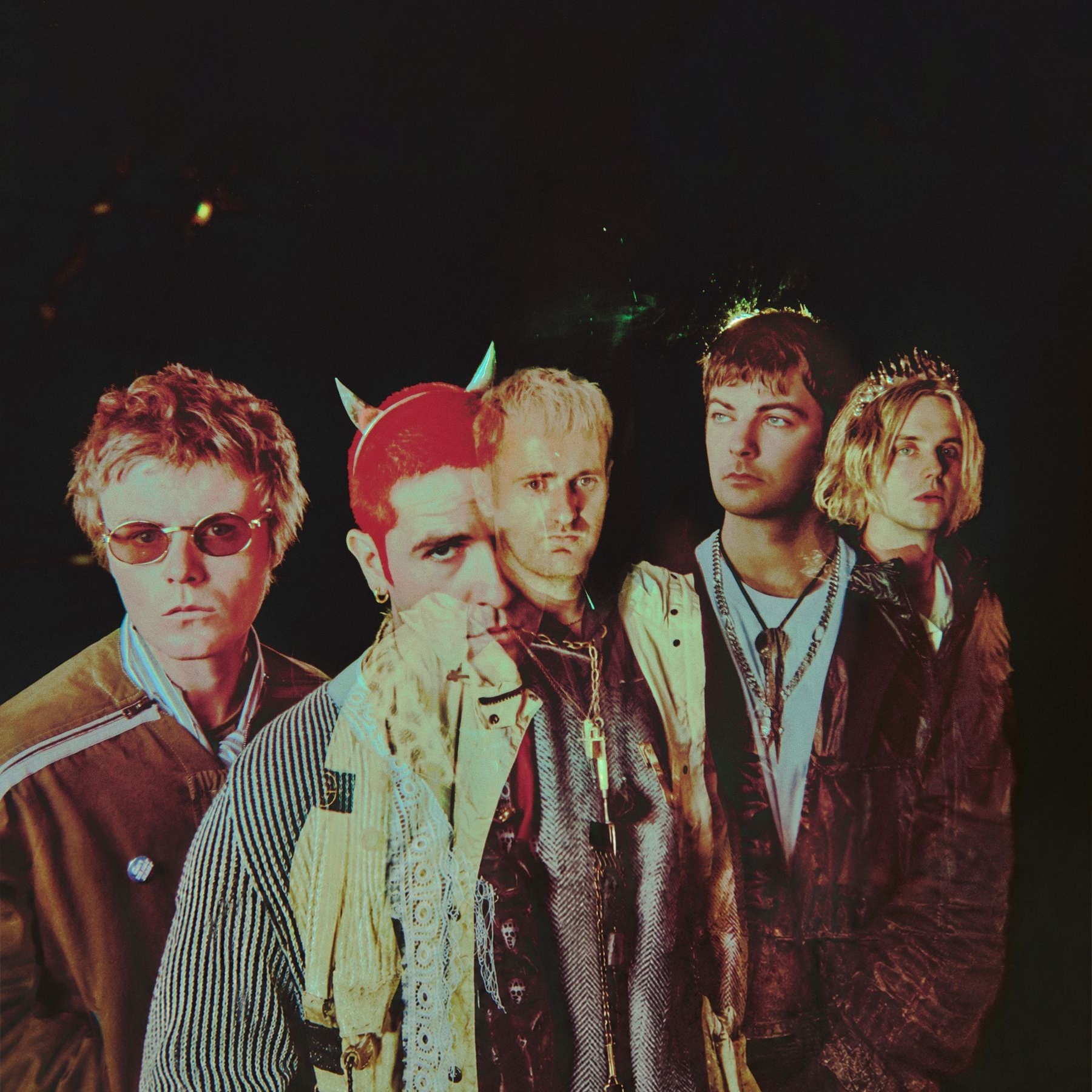 Five men in colorful clothes with a dark background