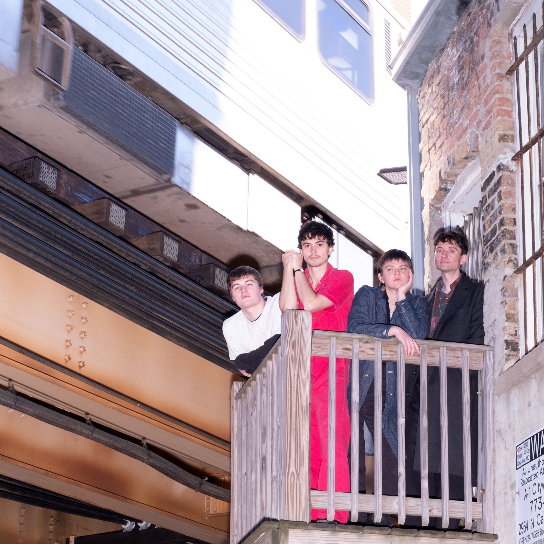 Four people standing on a balcony