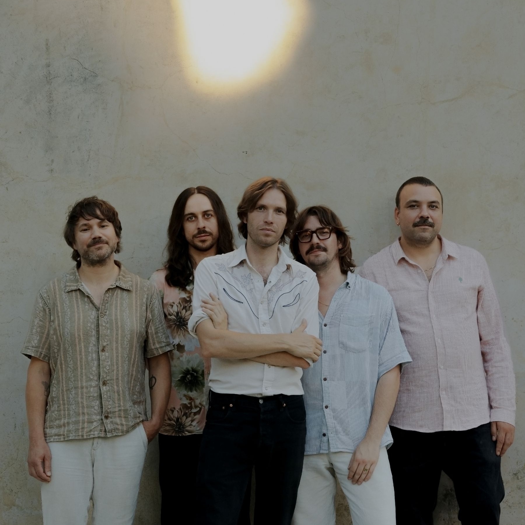 Five men standing in front of a wall