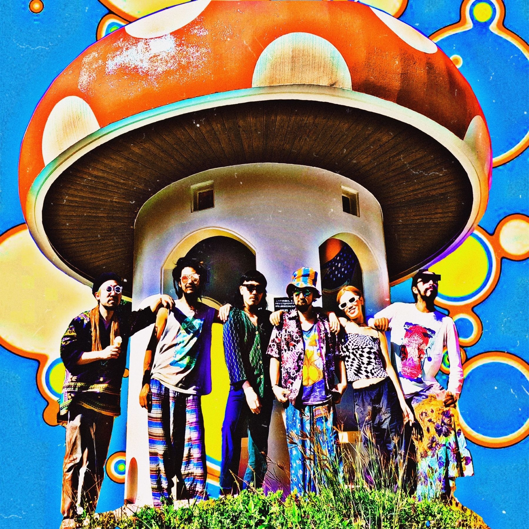 Six people standing in fornt of a big mushroom-shaped house