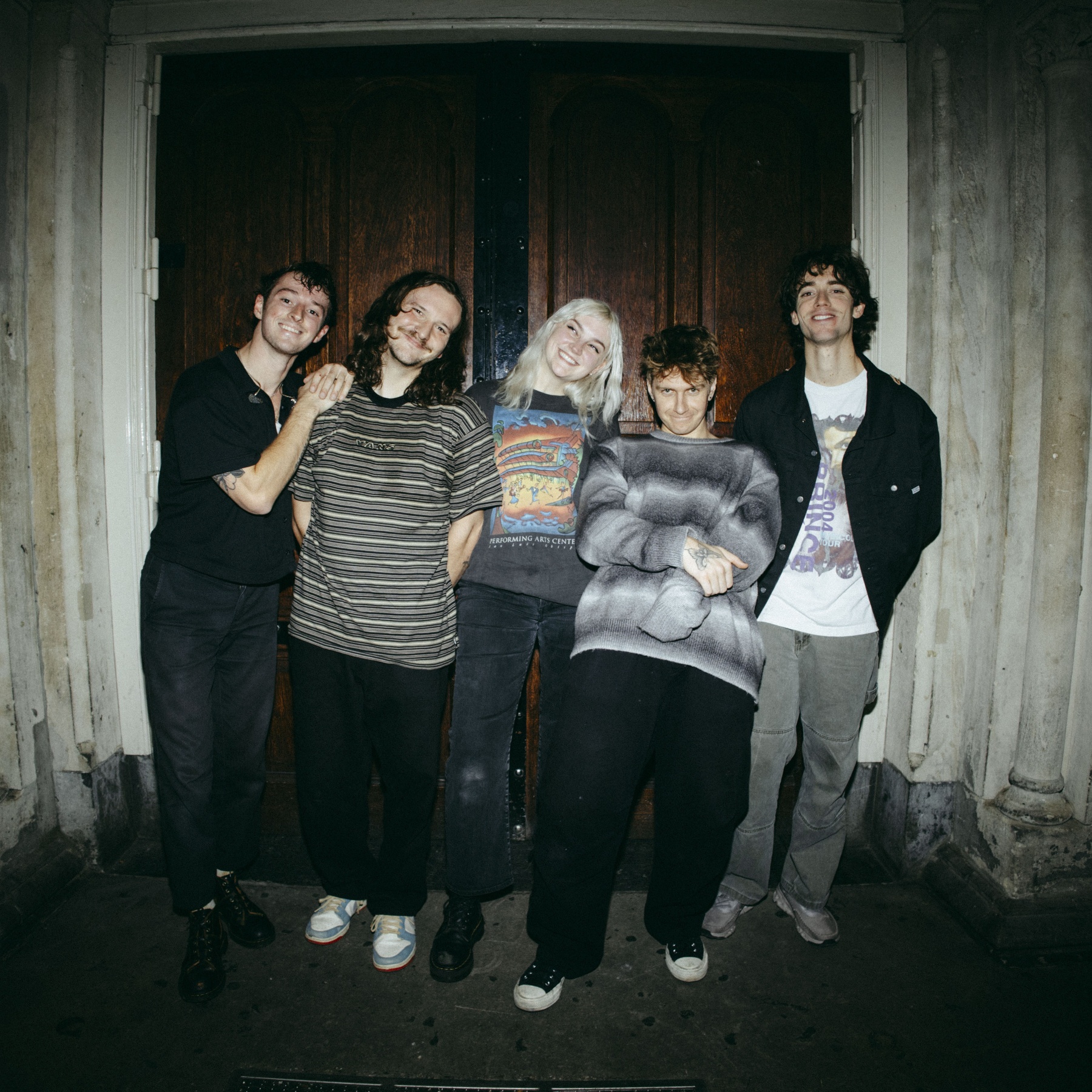 Five people standing in fornt of a door
