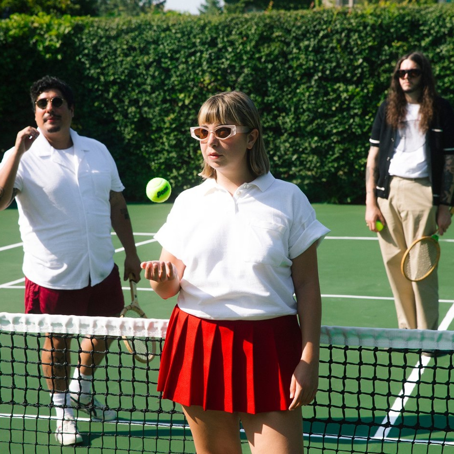 Three people on a tennis court