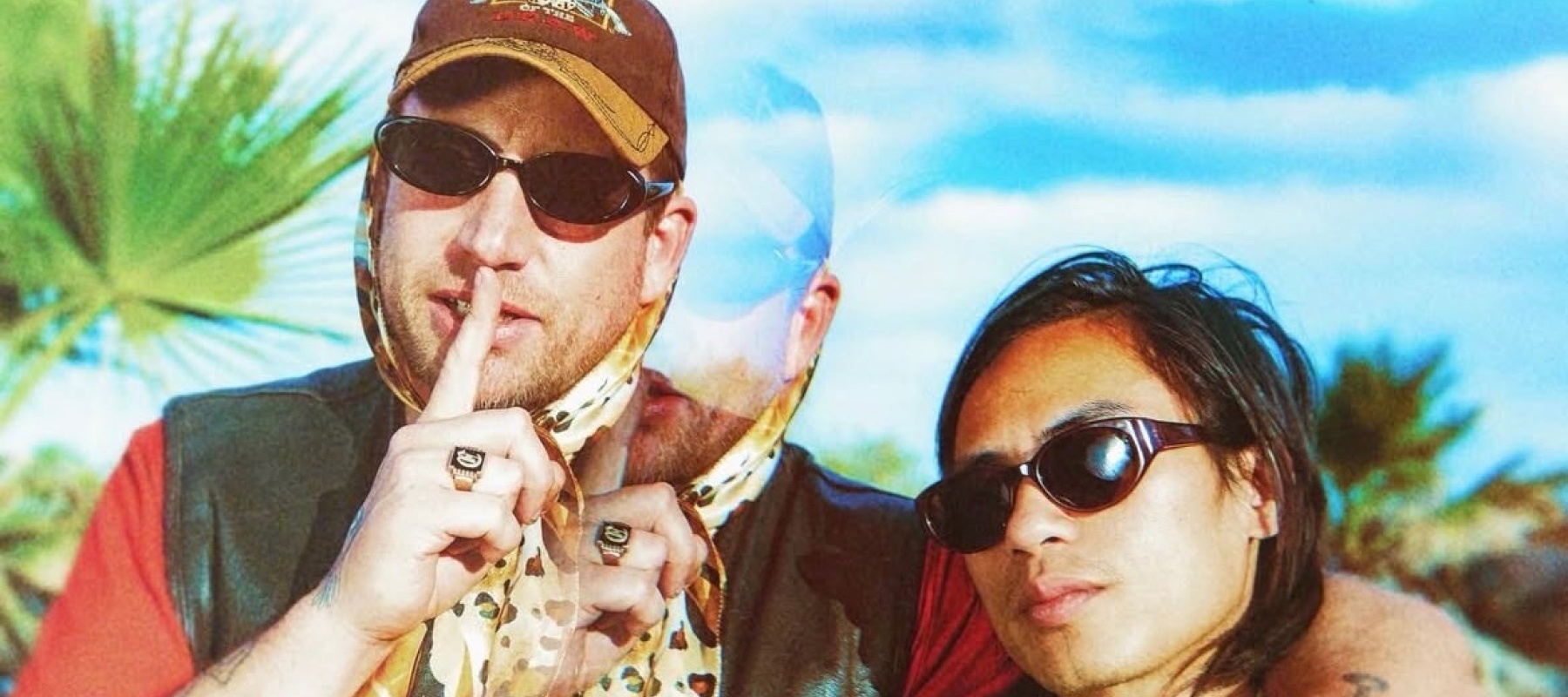 Two men posing with a blue sky in the back