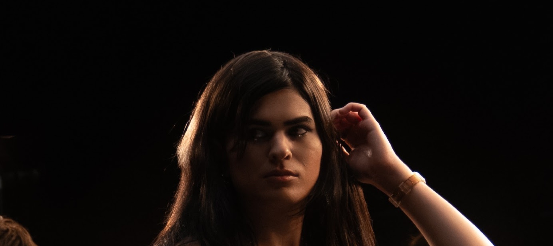 Woman posing against a dark background