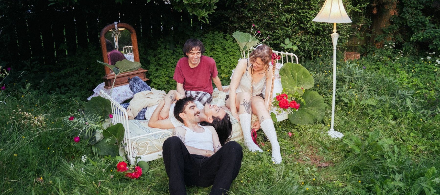 People laughing on a bed in a garden