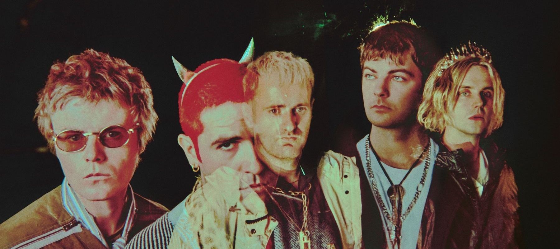 Five men in colorful clothes with a dark background