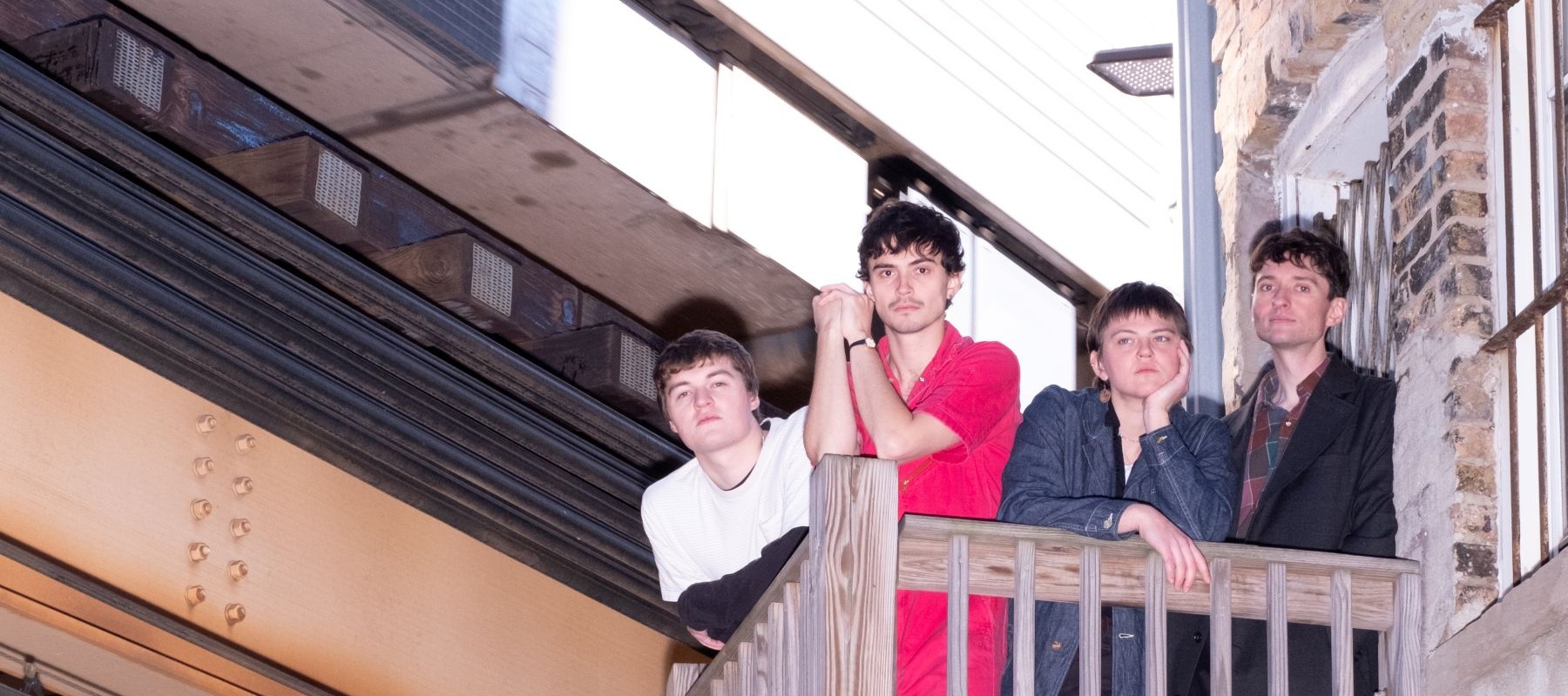 Four people standing on a balcony
