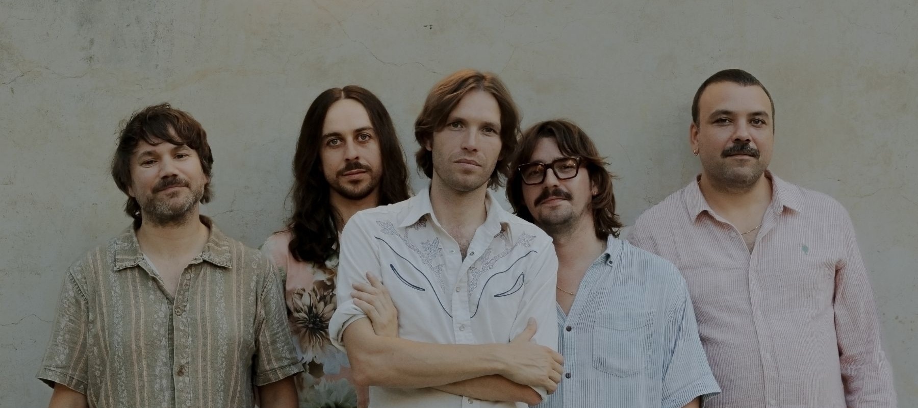 Five men standing in front of a wall
