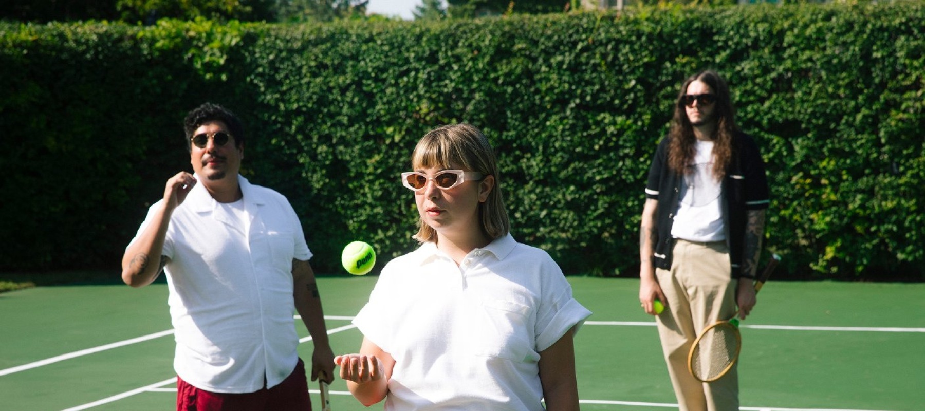 Three people on a tennis court
