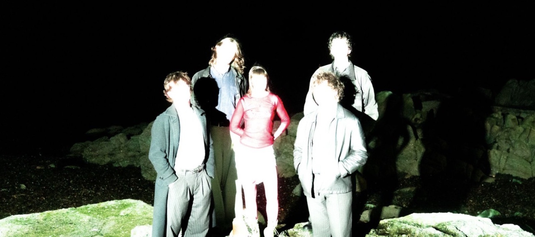 Five people standing in a field