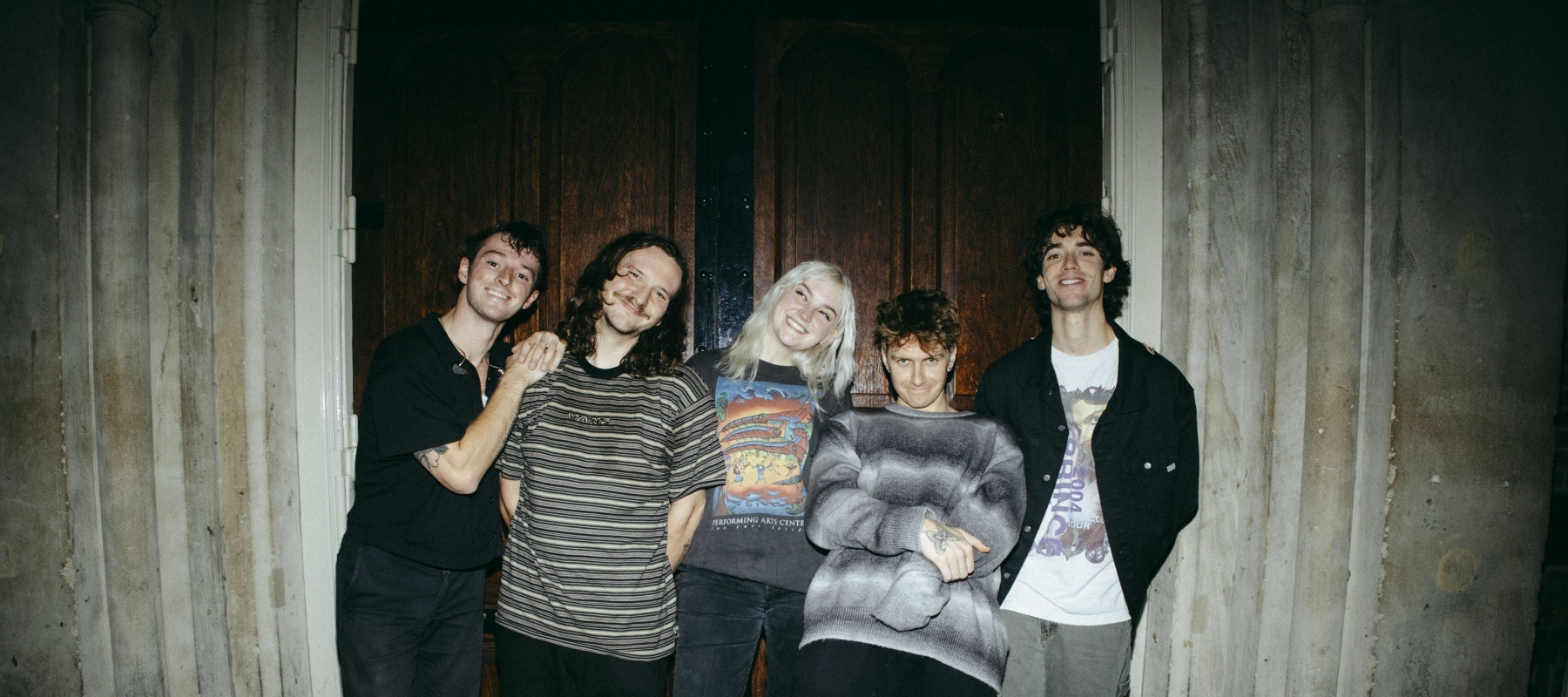 Five people standing in fornt of a door