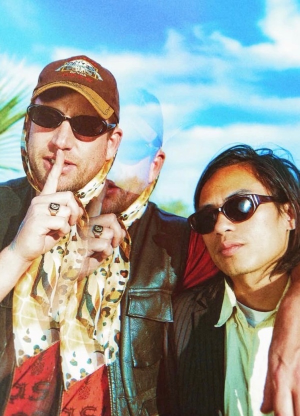 Two men posing with a blue sky in the back