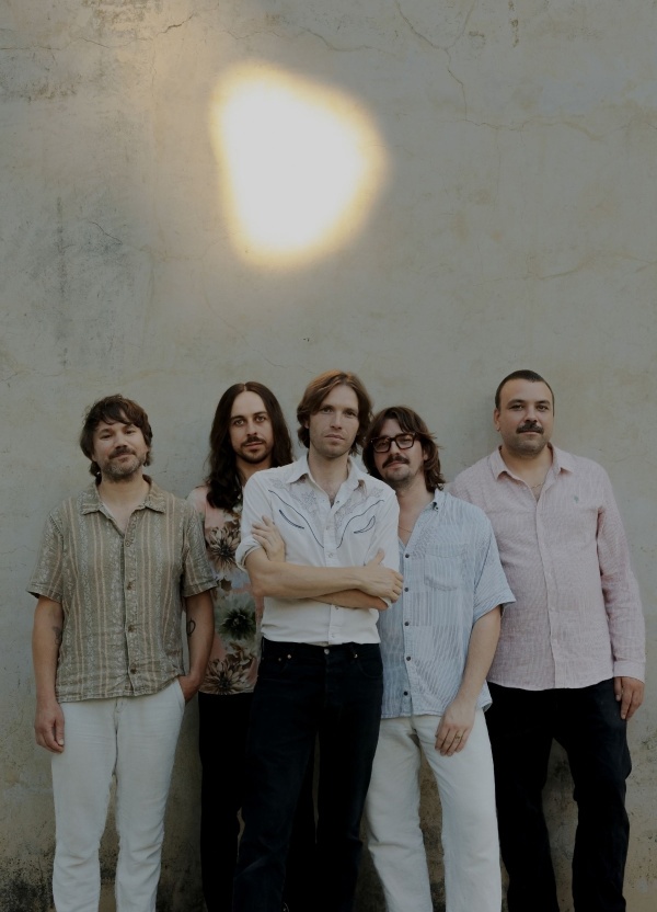 Five men standing in front of a wall