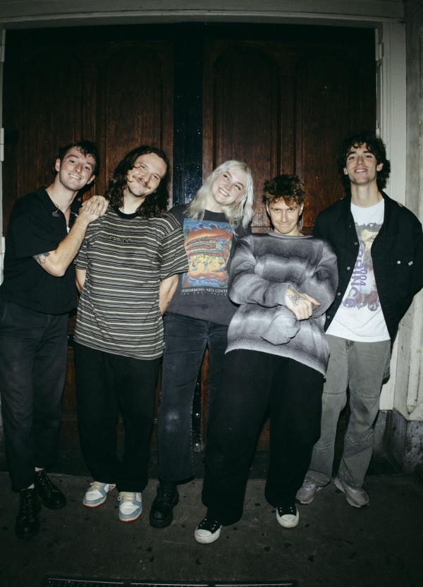 Five people standing in fornt of a door